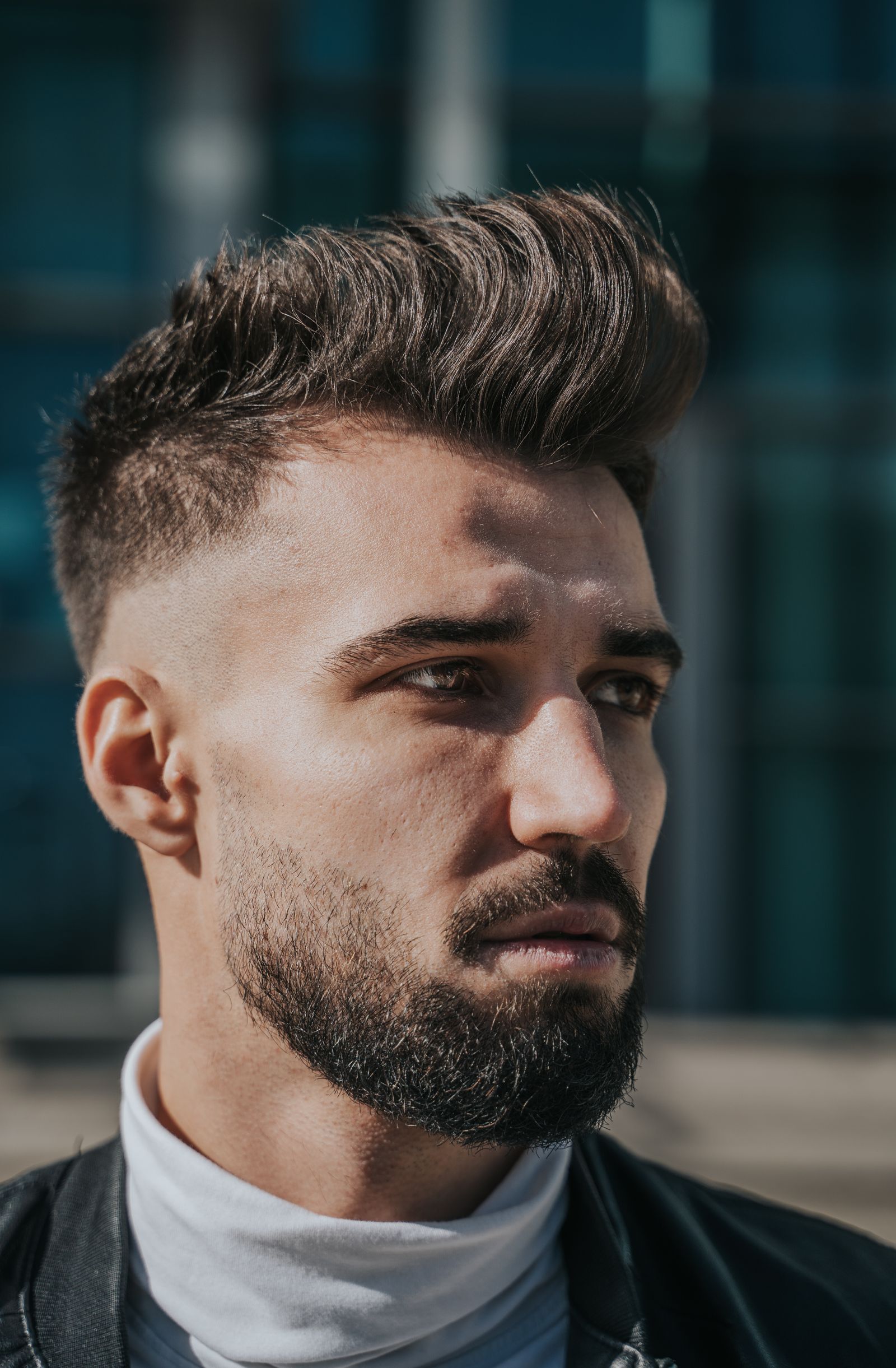 Man met baard en een quiff met volume aan de voorkant en een fade aan de zijkant