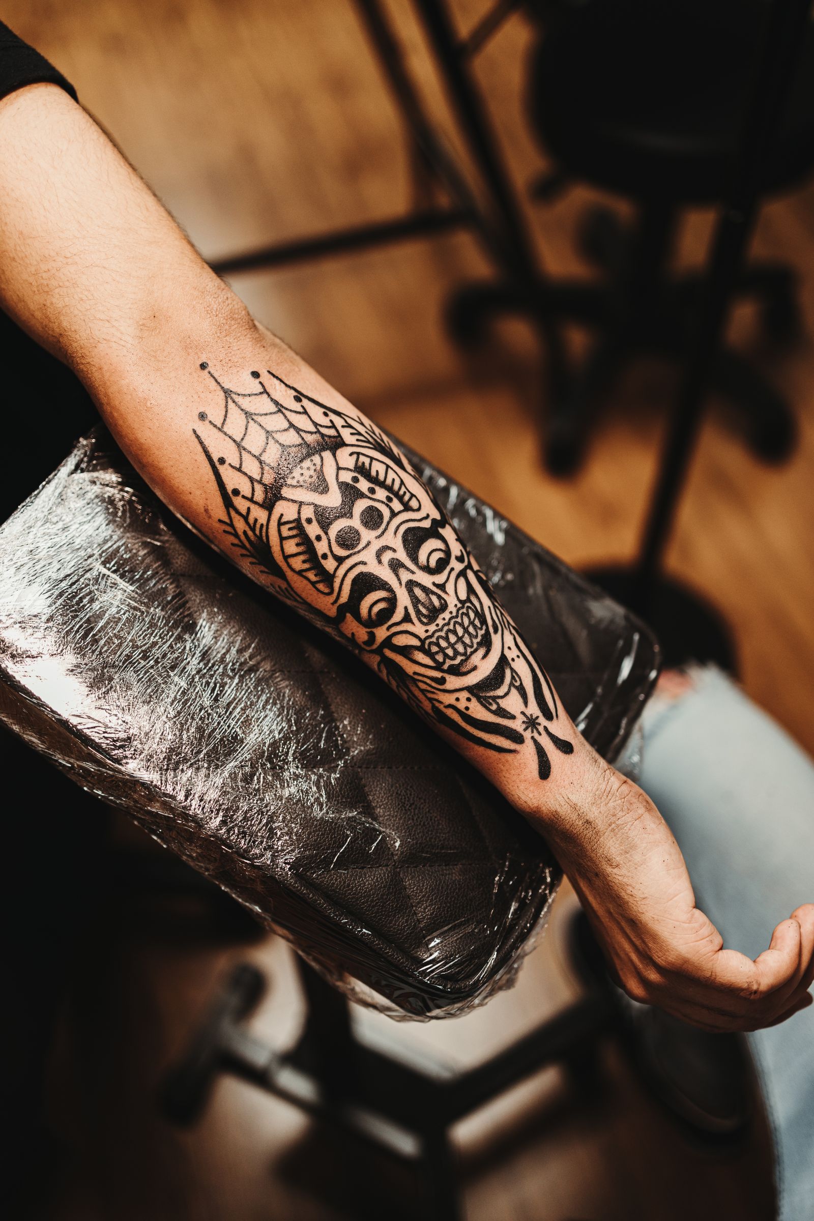 Verse blackwork tattoo van een schedel met een mandala op de onderarm van een man